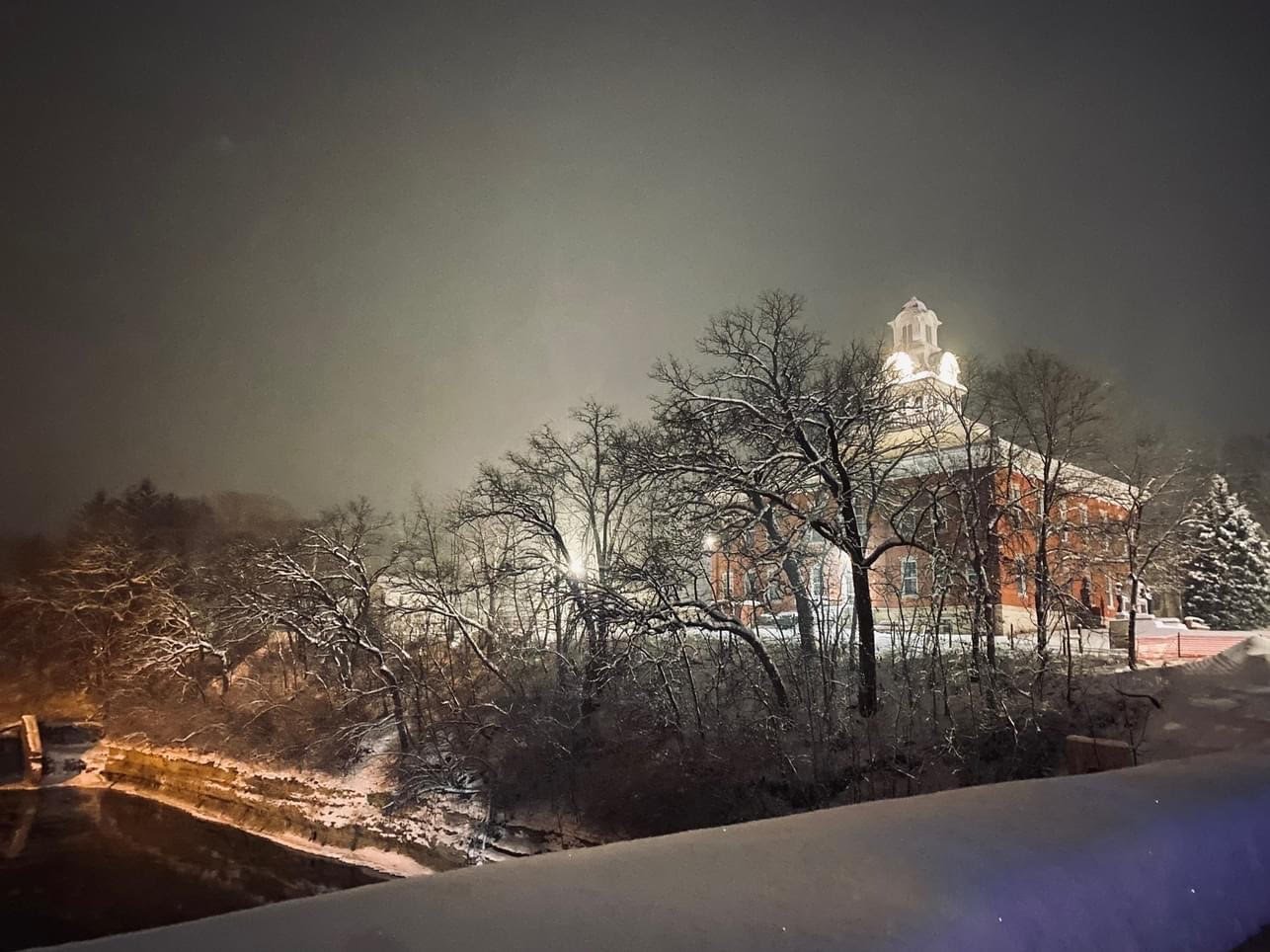 The Clayton County Courthouse on the bluff above the Turkey River on a snowy night in Elkader